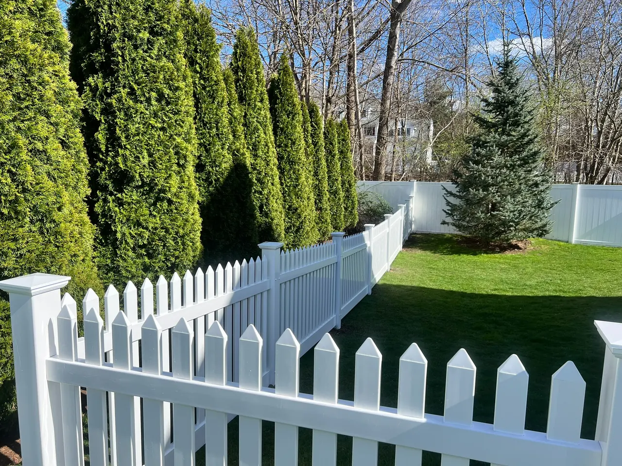Custom wood privacy fence installed beside a home by DM Fence Inc