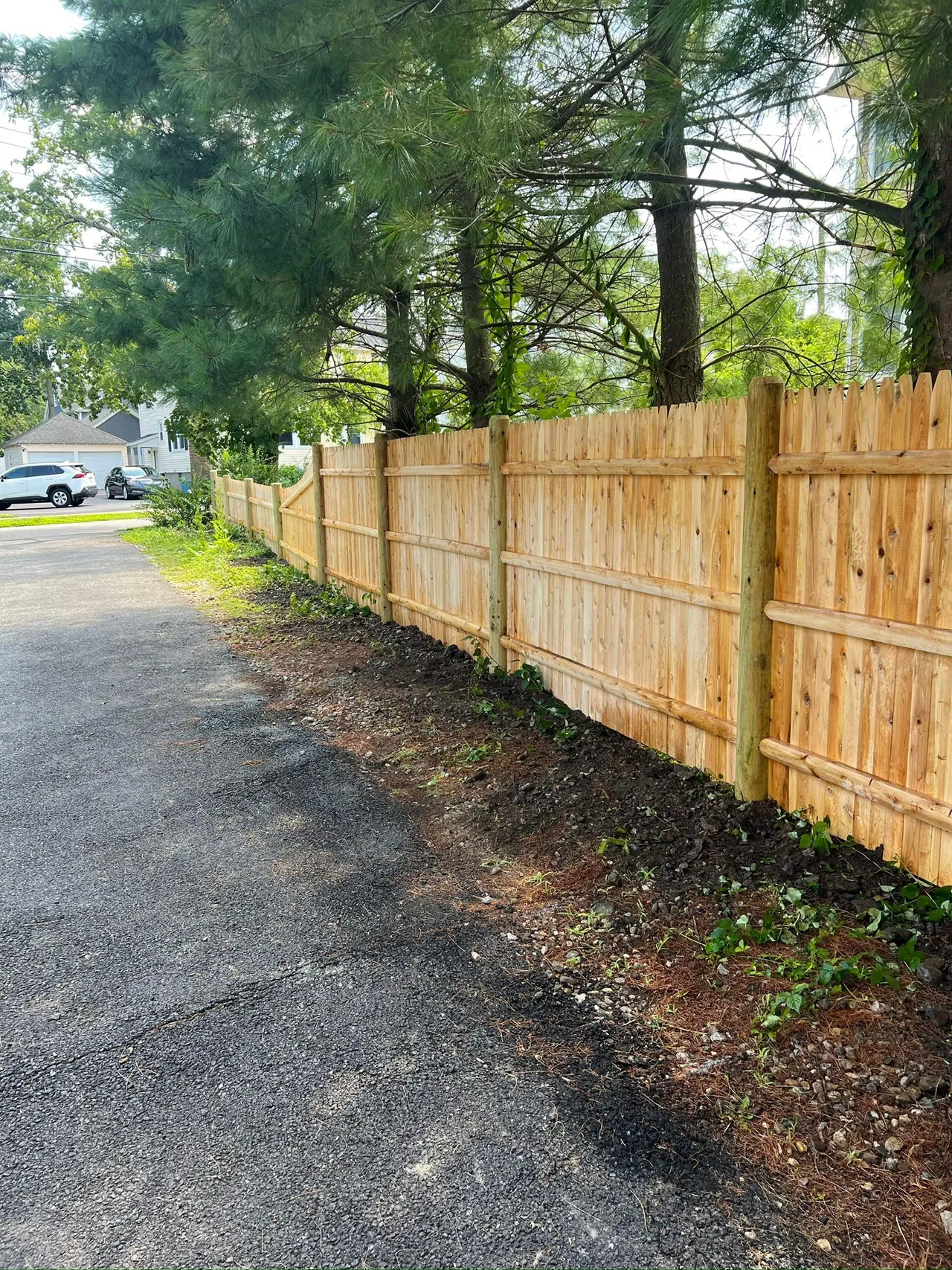Backyard wood privacy fence installation with long straight sections by DM Fence Inc